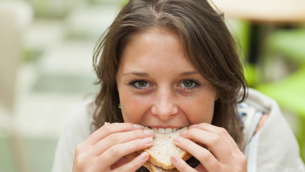 happy girl eating a sandwich