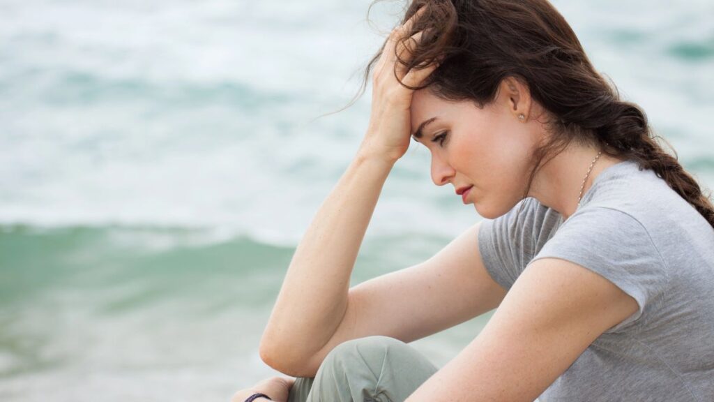 stressed and upset woman sitting by water