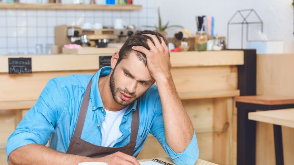 upset waiter sitting at table