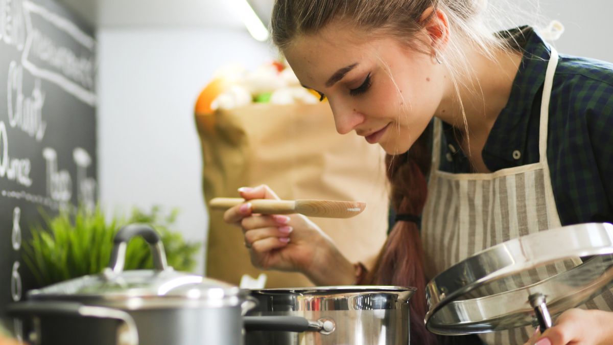 woman cooking and tasting