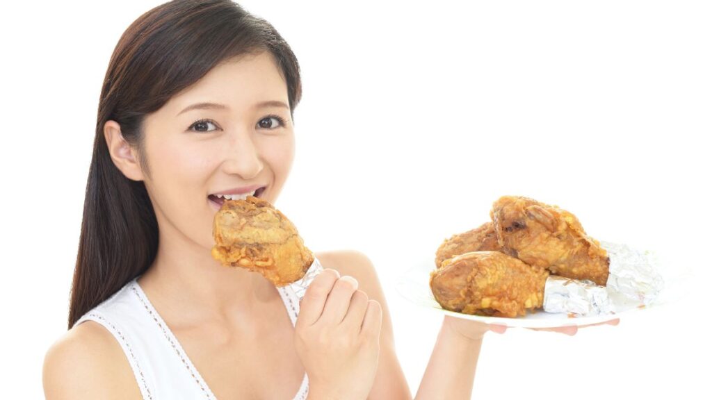 woman eating chicken on a plate