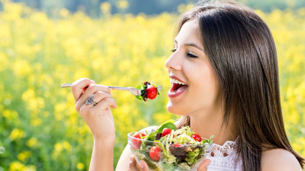 woman eating salad outside