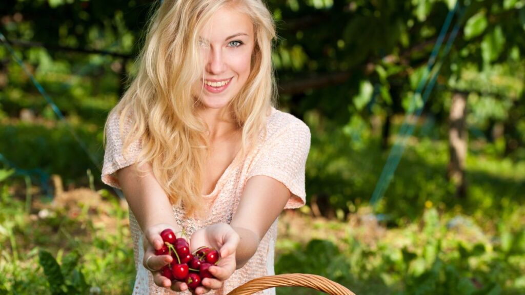 woman happy holding cherries outside