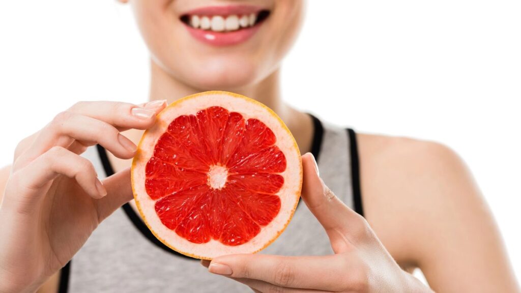 woman holding grapefruit