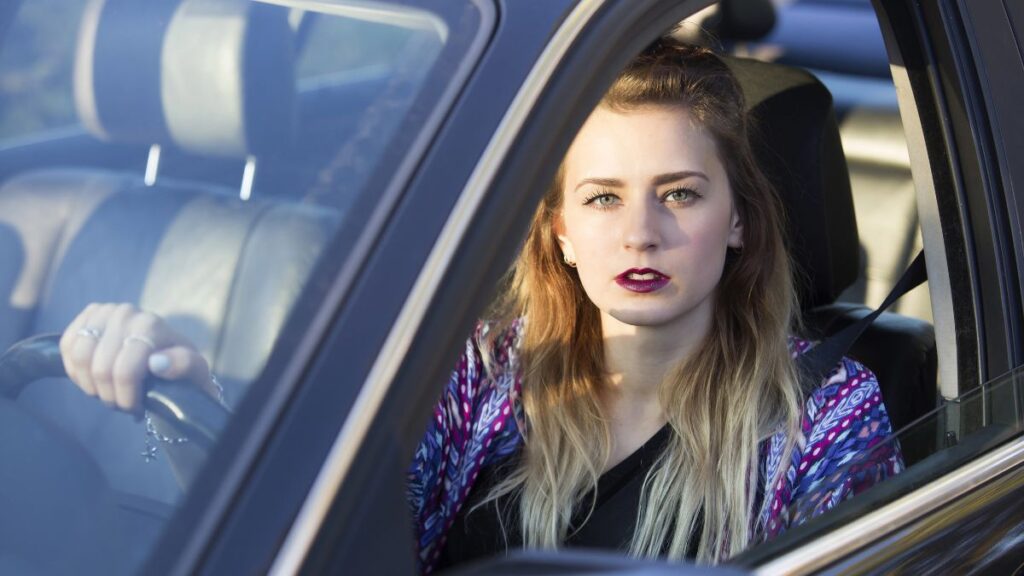 woman in car looking confused