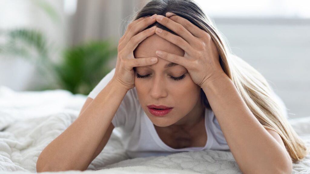 woman laying with headache