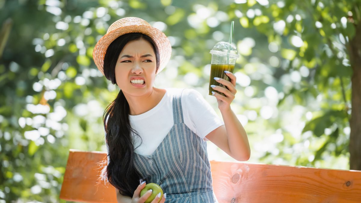 woman looking disgusted at drink