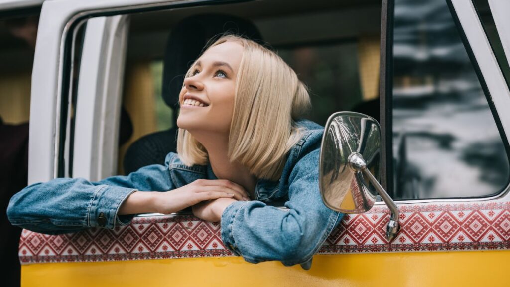 woman looking out of old car