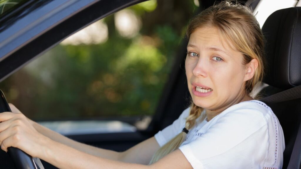 woman looking uncomfortable in drivers seat