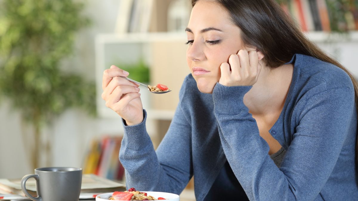 woman looking unhappily at food