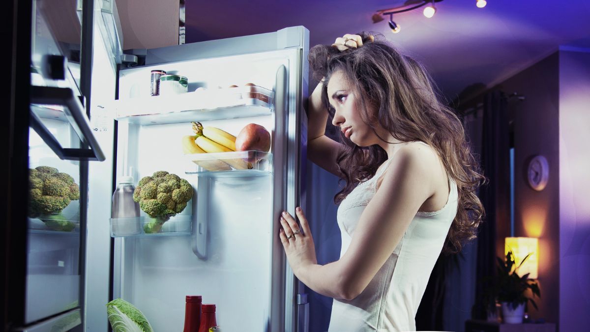 woman looking upset in fridge