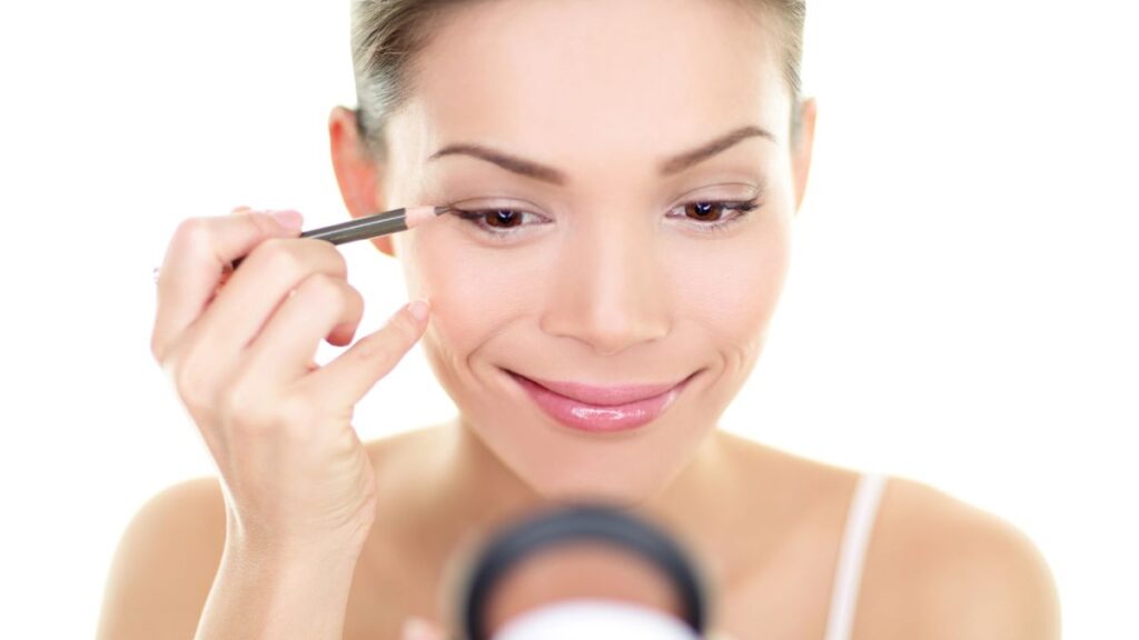 woman putting on eyeliner