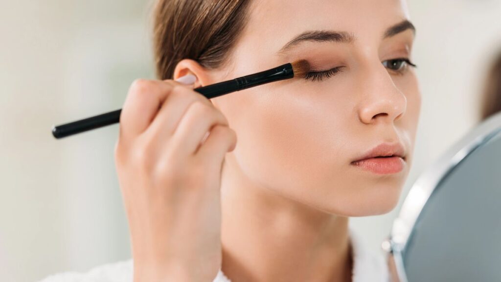 woman putting on eyeshadow