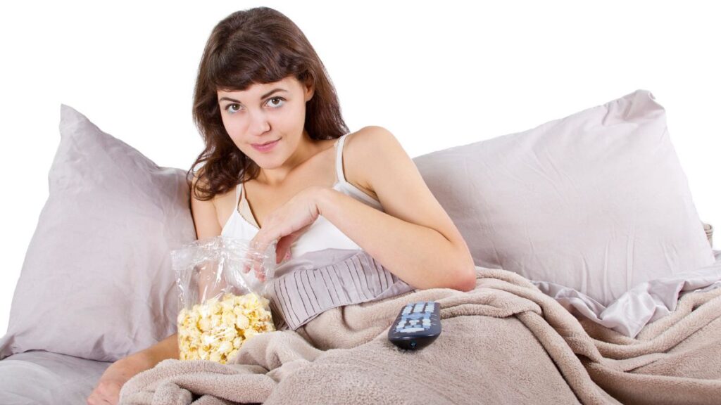 woman relaxing in bed with popcorn