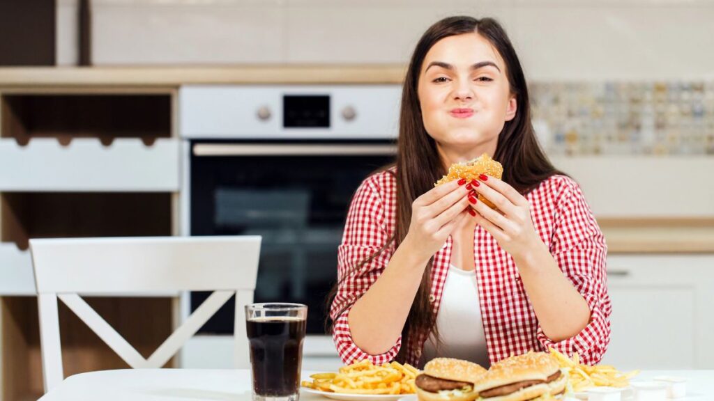 woman smiling with mouth full of burger