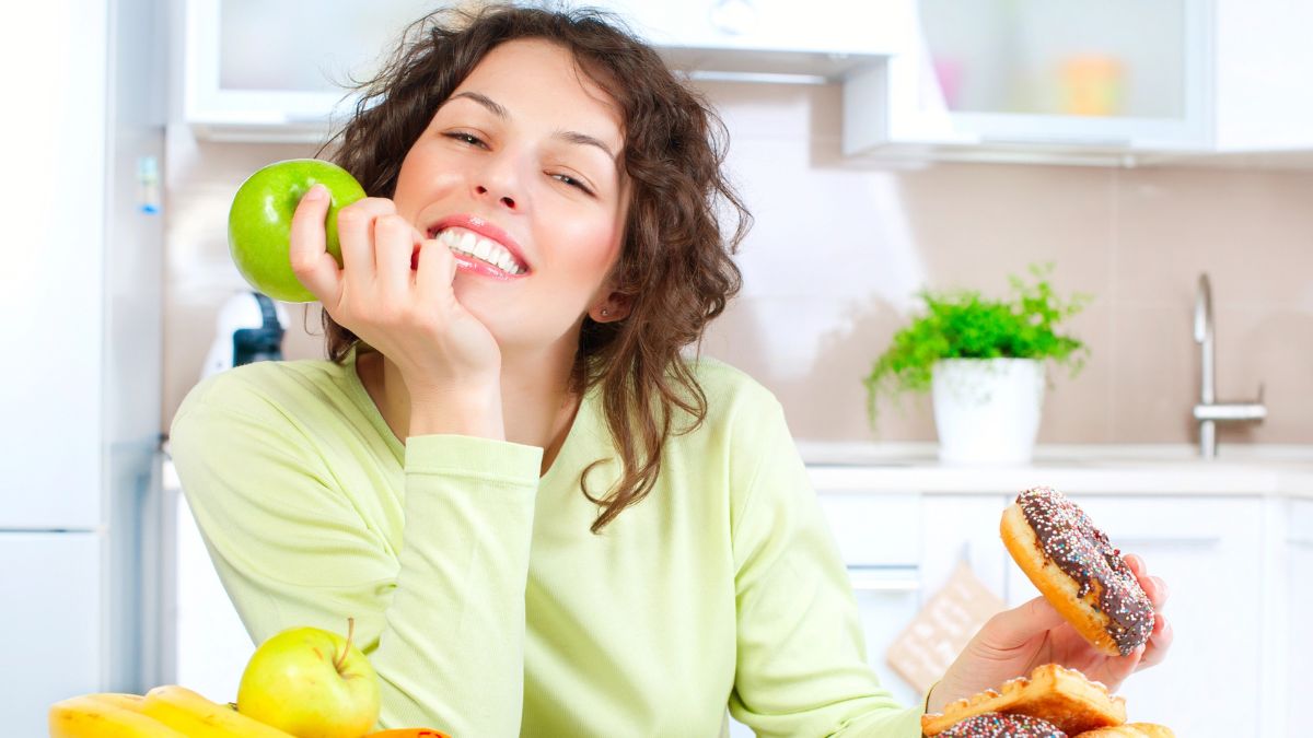 woman with apple and donut smiling