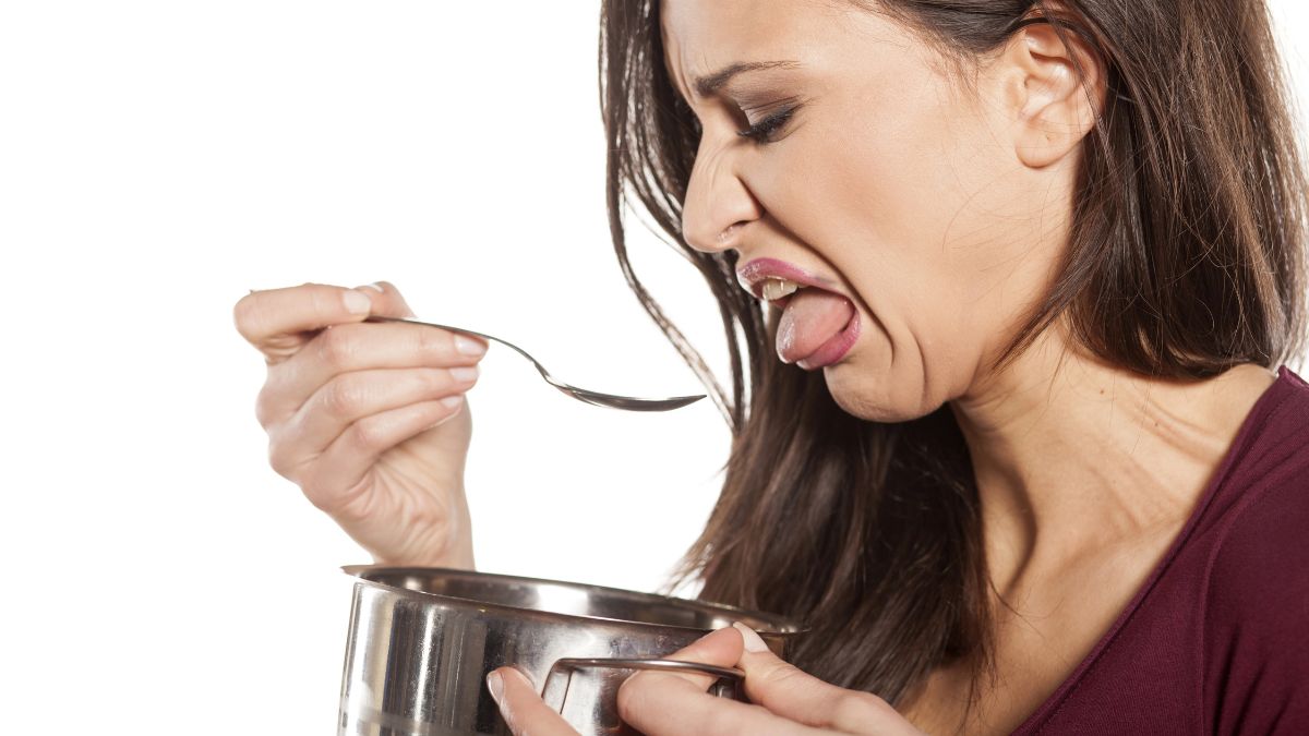 woman with disgusted face looking in pot