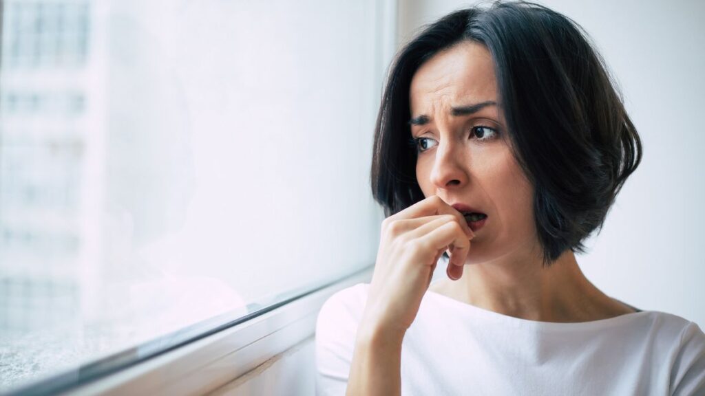 worried woman looking out the window