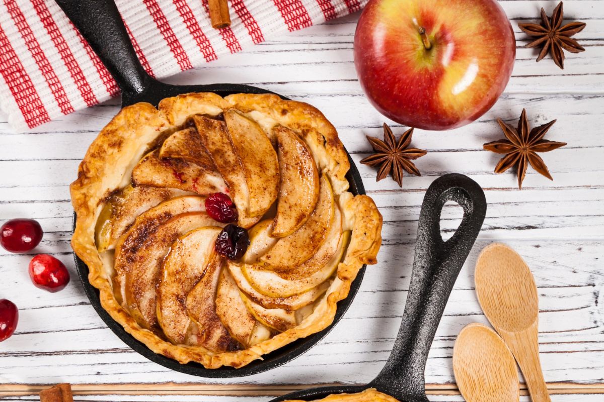 Apple pie on a table with apples