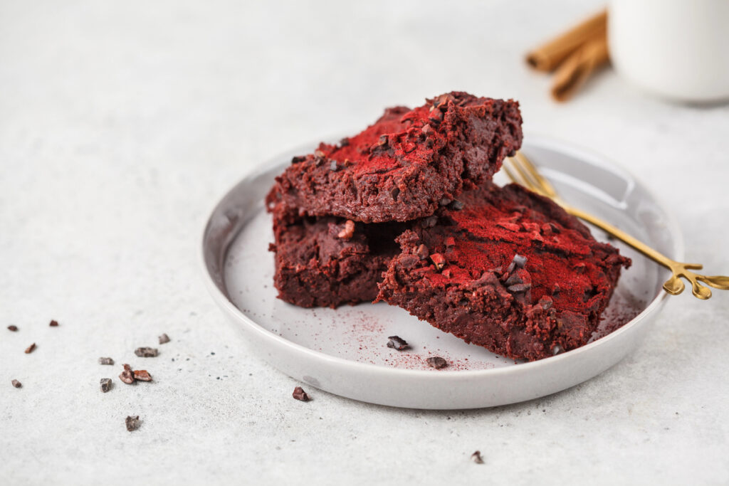 Beetroot vegan brownie on gray plate. Healthy vegan food concept.