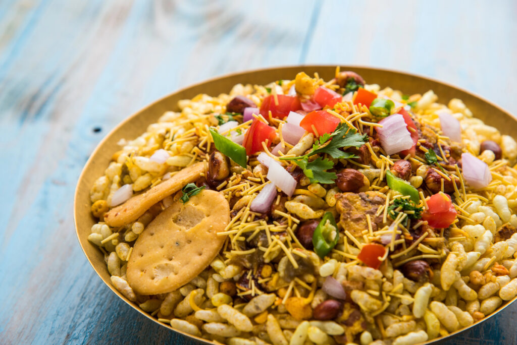 Indian snacks Bhel Puri served with chopped tomatoes and onion