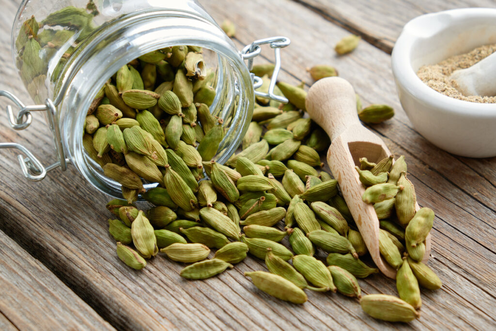 Green aromatic cardamom pods. Jar of whole cardamom