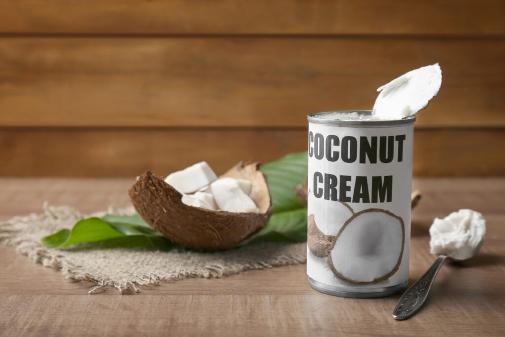 Coconut cream in opened tin on wooden table