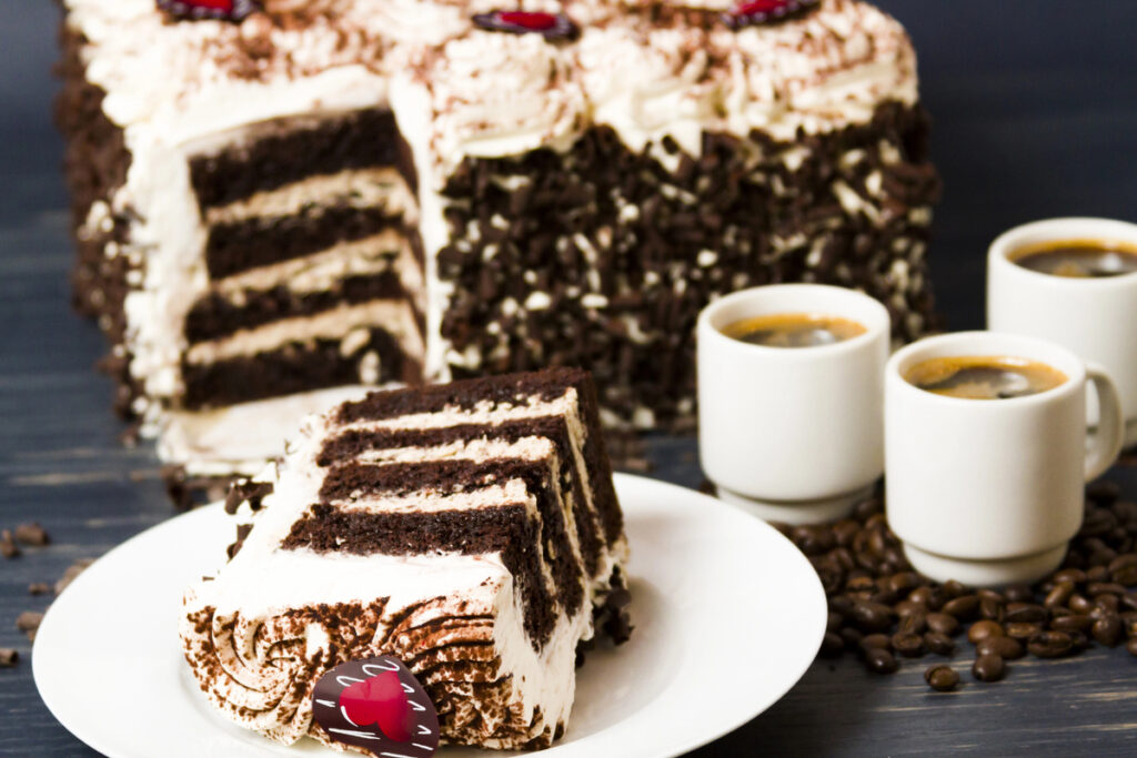 Tiramisu cake, multiple layers of espresso infused chocolate cake, filled with chocolate mascarpone mousse and topped with whipped cream.