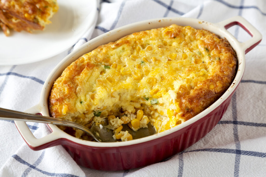 Homemade Cheddar Corn Pudding Casserole, low angle view. Close-up.