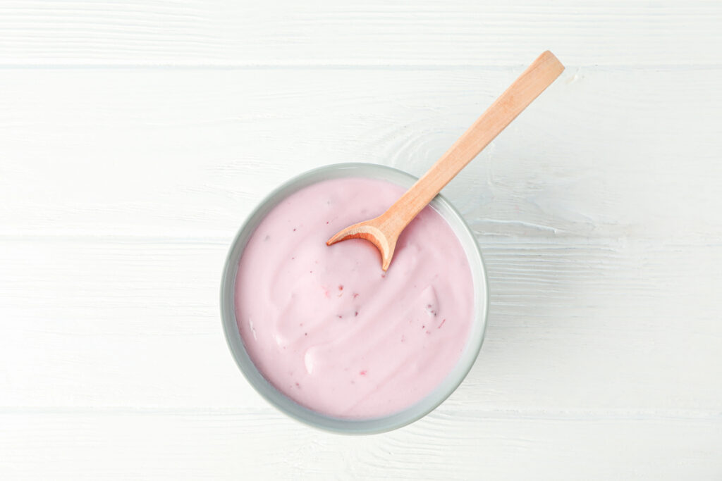 Fruit yogurt in bowl and spoon