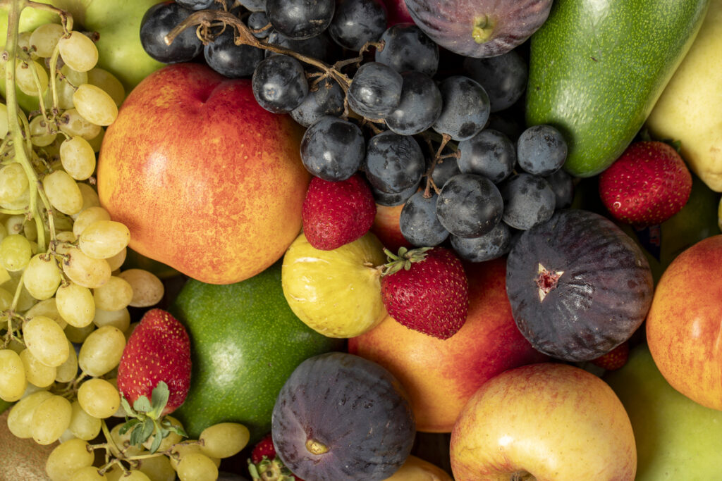 Fresh fruits.Various fruits colorful background. Grape, Fig, Strawberry, apple, pear, kiwi, peach. Top view