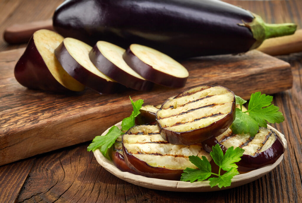 grilled eggplant and parsley leaves on wooden table