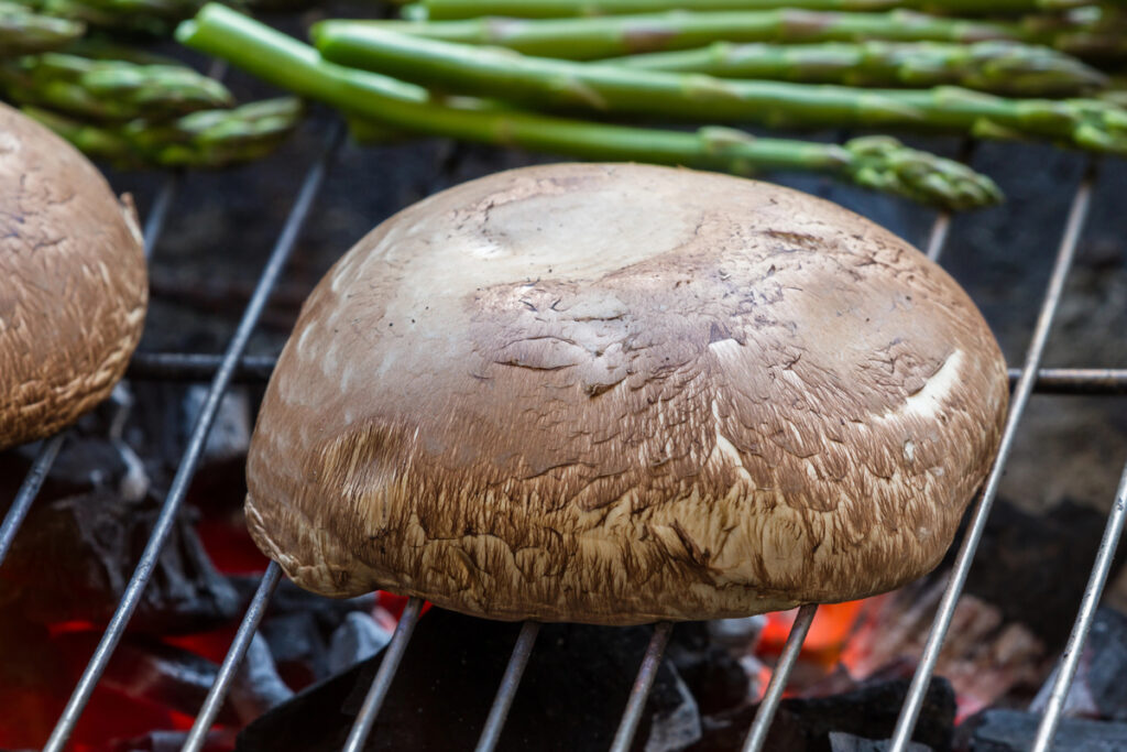 grilling portobello mushrooms and fresh asparagus over hot charcoal