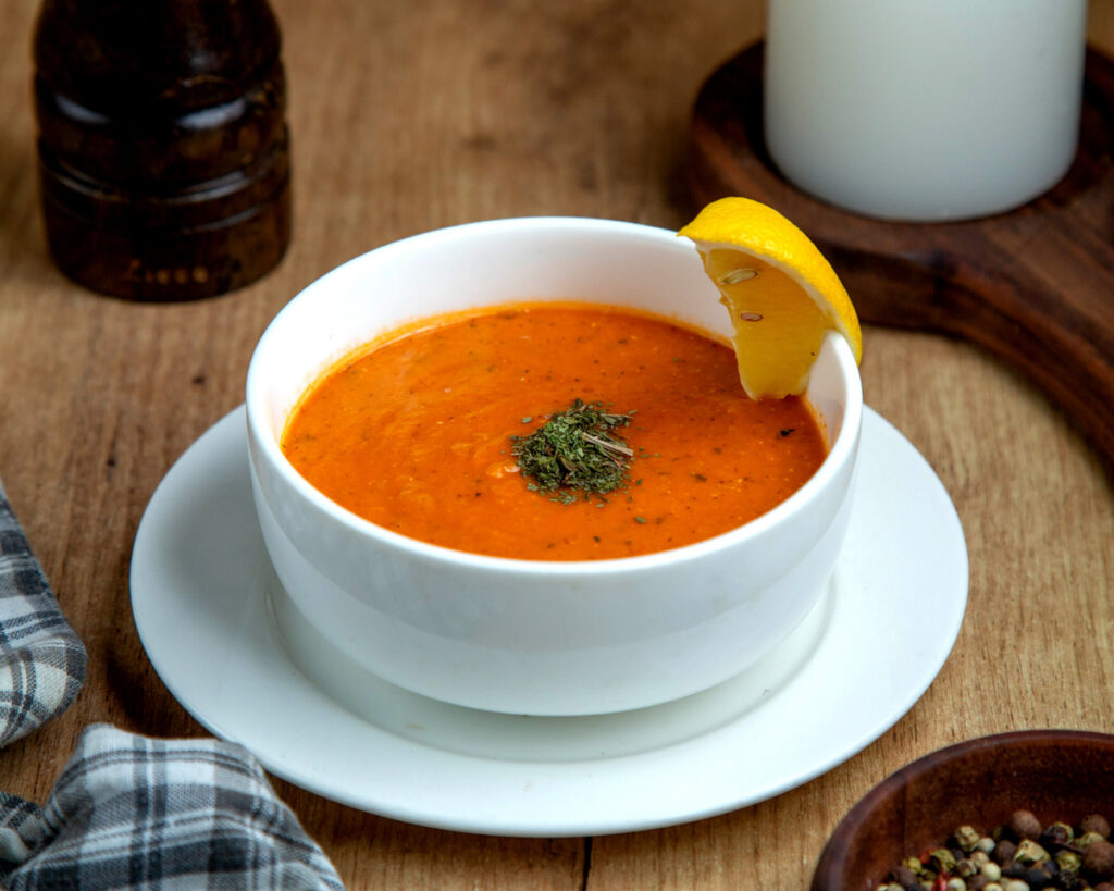 A bowl of lentil soup garnished with lemon slice