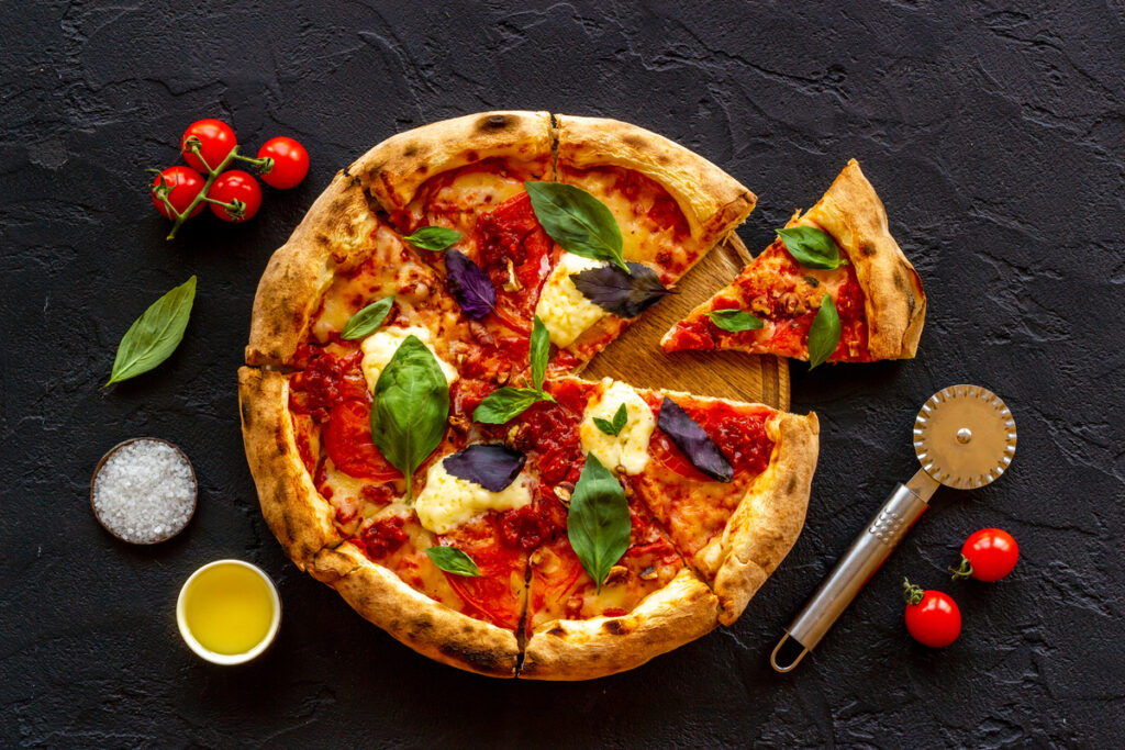 Homemade italian pizza margherita with tomatoes cheese and basil, top view.