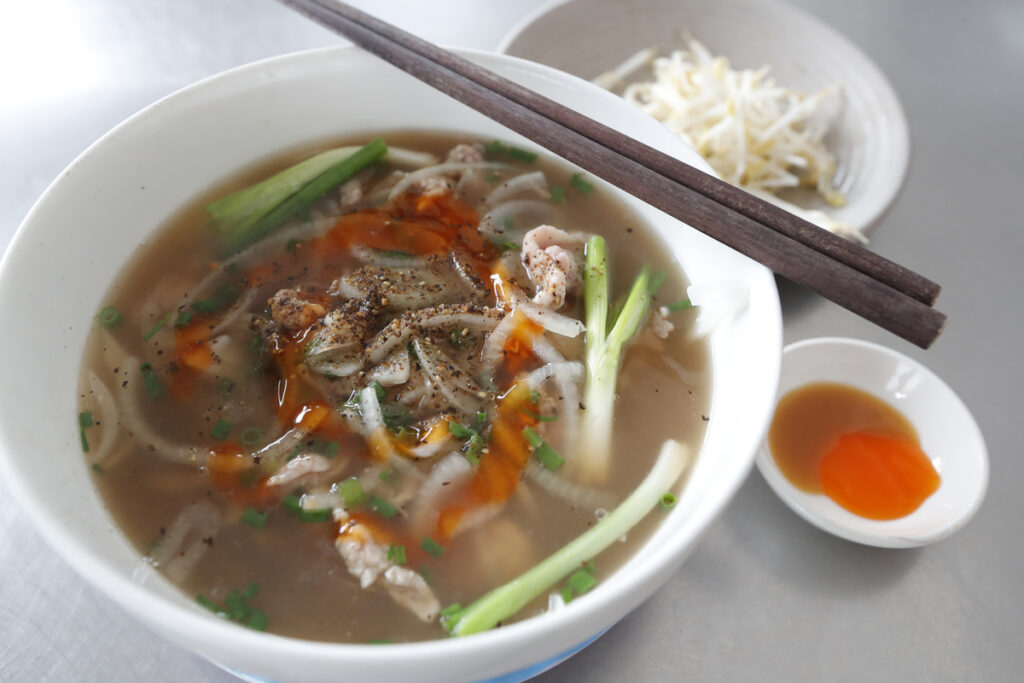 Bowl of  Vietnamese tradional pho chicken noodle soup in a street restaurant.  Tan Chau. Vietnam.