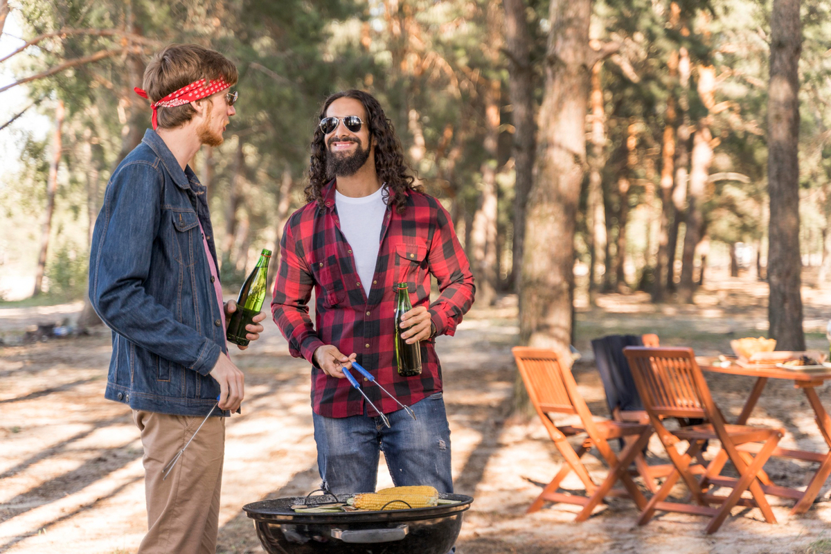 Male friends conversing over beer and barbecue