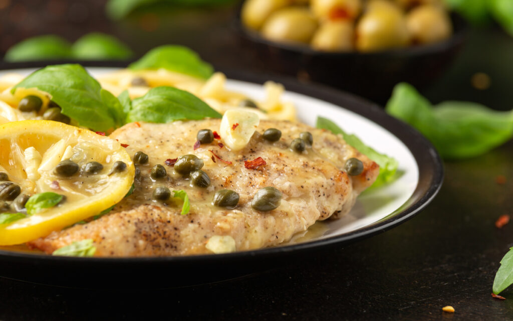 Chicken Piccata with capers, white wine sauce and spaghetti. Italian food.