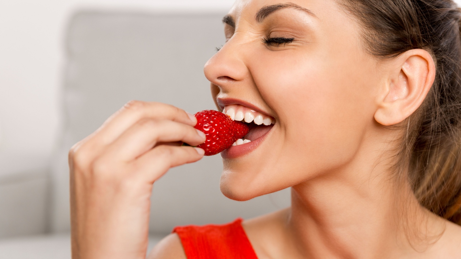 beautiful happy woman eating strawberry