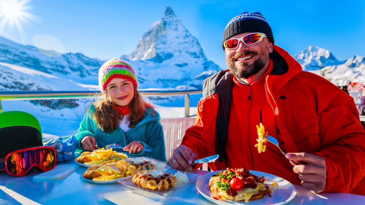 dad and daughter eating in mountains