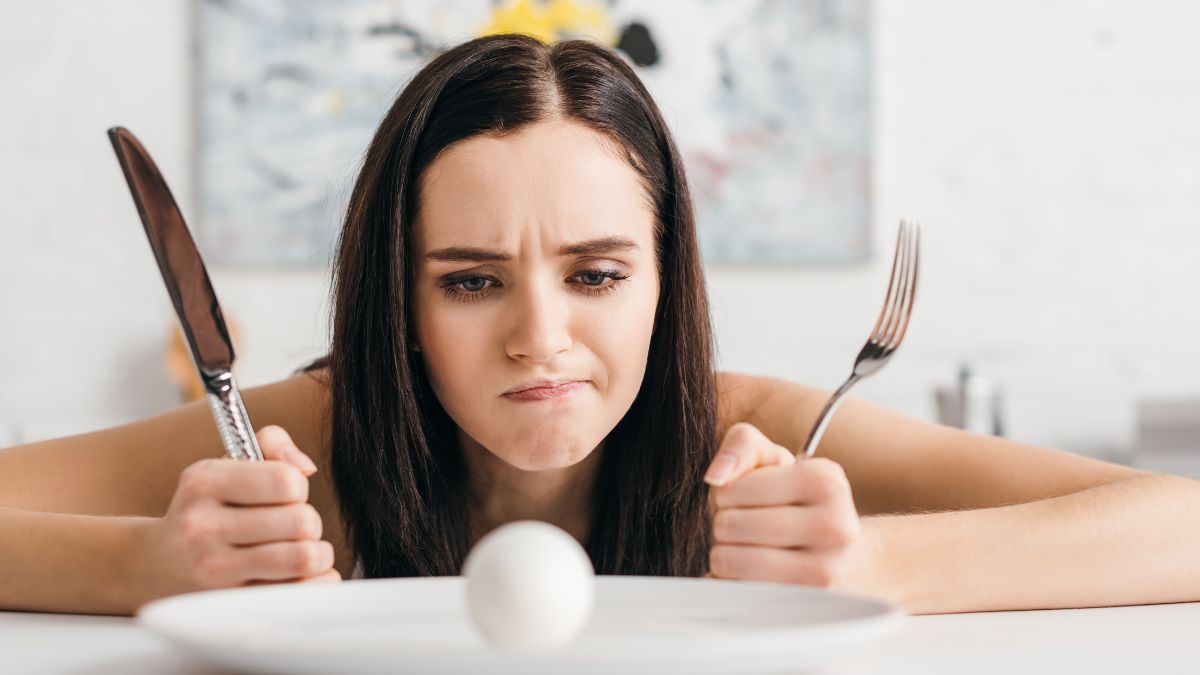 frustrated woman looking at egg