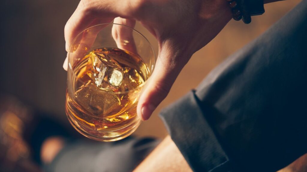 hand with glass of bourbon