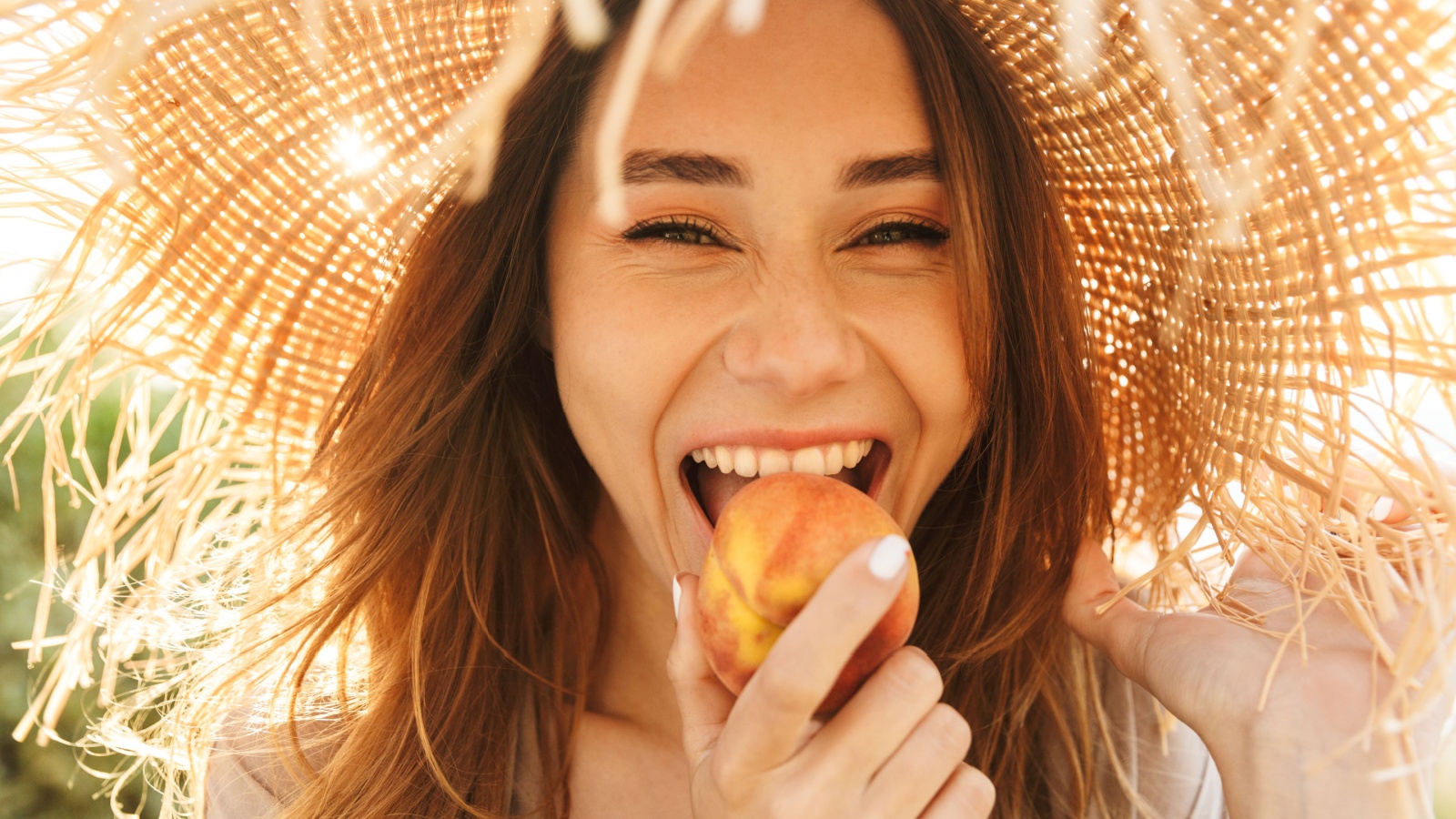 happy eating peach in straw hat