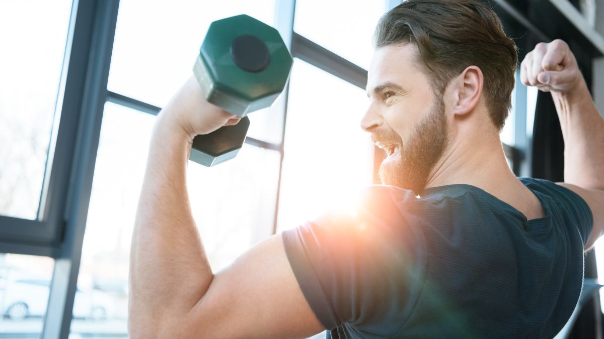 happy man flexing with weights