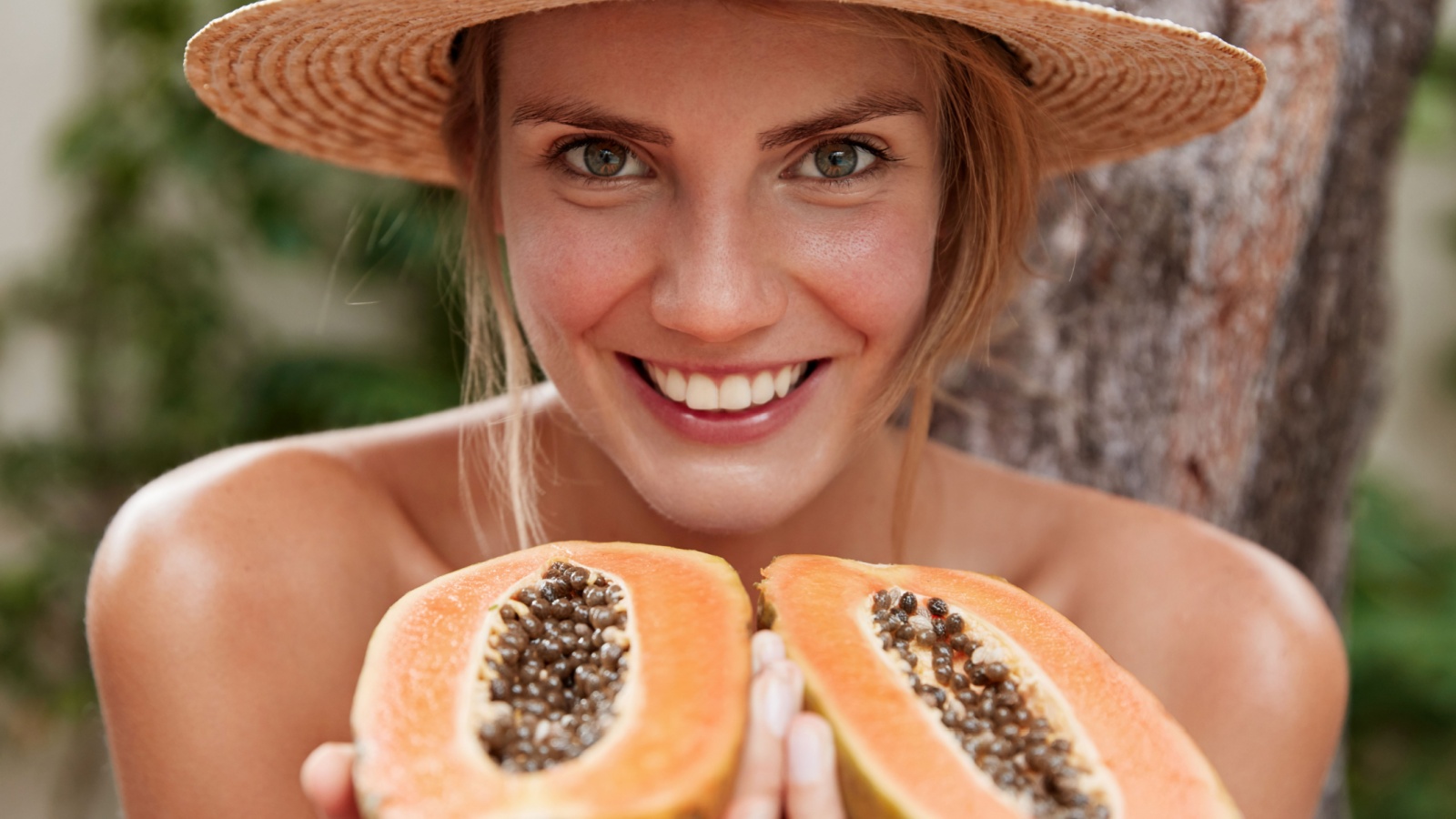 happy woman holding papaya fruit