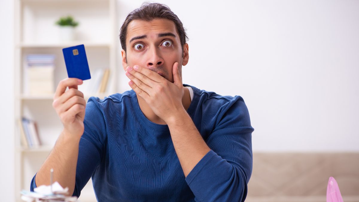 man looking scared and stressed with credit card