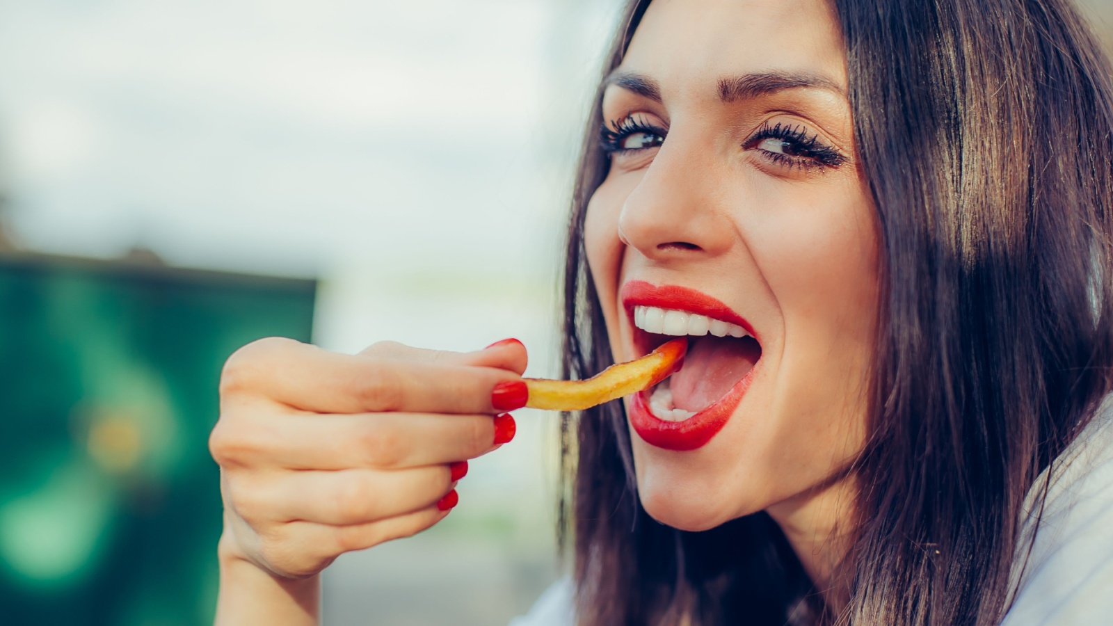 woman eating French fry junk food