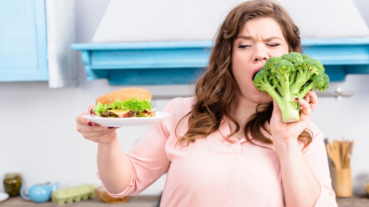 woman eating broccoli holding sandwich