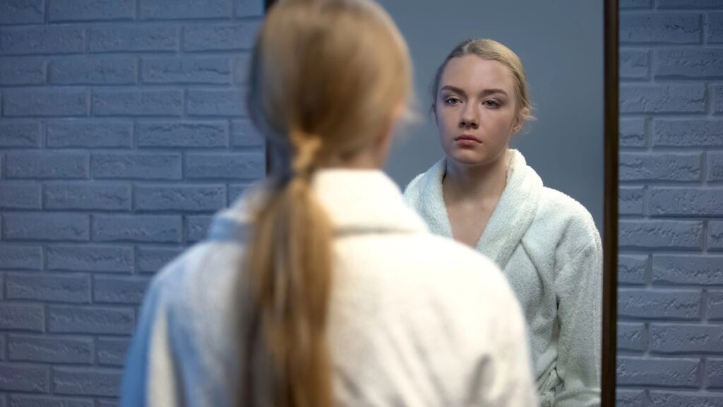 woman looking sick in mirror