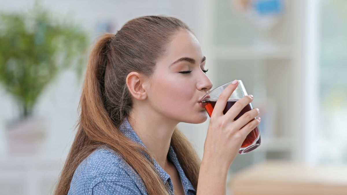 woman with eyes closed drinking cherry juice